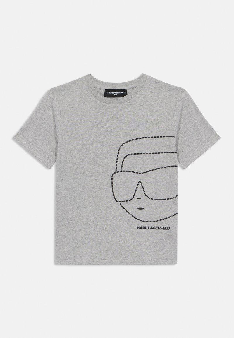 Pelēks kokvilnas T-krekls ar melnu punktiņu grafiku, kurā attēlotas brilles un seja uz priekšpuses. Uz etiķetes apakšējā daļā ir rakstīts "KARL LAGERFELD".