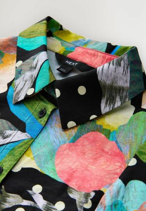 Košile s límečkem, černobílé puntíky a barevným abstraktním květinovým vzorem, s viditelnou štítkem značky "NEXT".