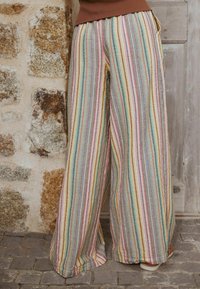 Laiade püksid tekstuurse kangaga, millel on vertikaalsed mitmevärvilised triibud roosa, kollase, rohelise, sinise ja halli toonides. Sisaldavad taskuid.