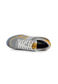 Scarpa sportiva grigia con tomaia in rete, dettagli gialli e lacci bianchi. Punta rotonda e suola ammortizzata progettata per comfort e supporto.