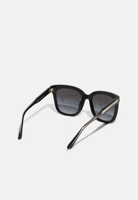 Black oversized sunglasses with gradient lenses, smooth plastic frame, and metallic accent on the temples. Stylish square shape.