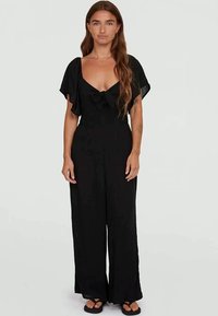 Black jumpsuit with short, flutter sleeves, a tie detail at the neckline, and wide-leg pants, made from lightweight fabric.