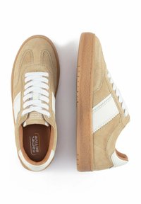 Beige Wildleder-Sneaker mit weißen Lederakzenten, strukturiertem Gummi-Sohle und weißen Schnürsenkeln. Mit einer abgerundeten Zehenpartie und kontrastierenden Nähten.
