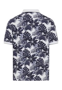 Polo à manches courtes en blanc avec un motif de feuilles tropicales bleu foncé. Présente un col slim et un liseré contrasté sur les manches.