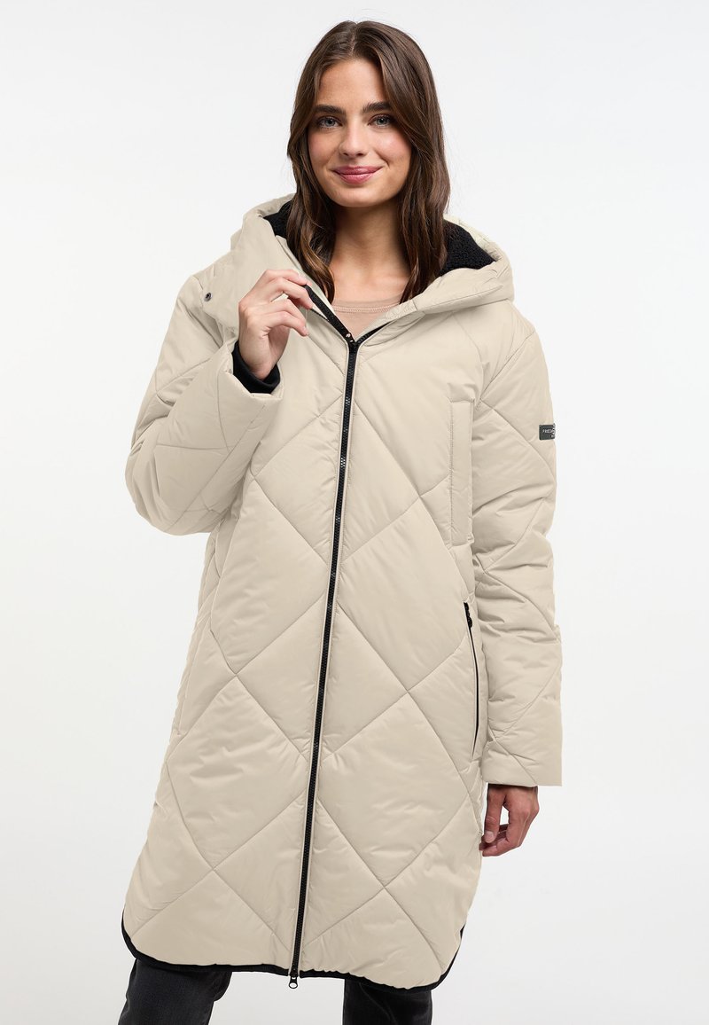 Beige, lange gewatteerde jas met een capuchon, voorzien van een ruitpatroon, een voorrits en zijzakken. Zwarte accenten aan de zoom.
