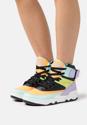 Vysoké tenisky s kombinací oranžové, černé, mátově zelené a levandulové. Mezi rysy patří pásek, texturované panely a kontrastní podešev.