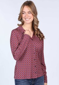 Long-sleeve blouse in rich purple with a swirling pattern in pink and beige. Features a collared neckline and front buttons. Fabric is smooth.