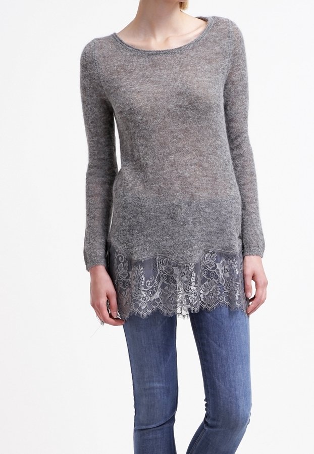 Pull en tricot gris à manches longues, avec une bordure en dentelle à l'ourlet et une texture douce, associé à un jean en denim bleu.