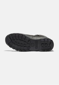 Suola in gomma nera con tacchi profondi e logo Timberland, attaccata a una parte superiore grigia texturizzata con una zip su un lato.