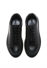 Black leather sneakers with round toe, smooth texture, and tonal laces. Features a minimalist design and textured rubber sole.