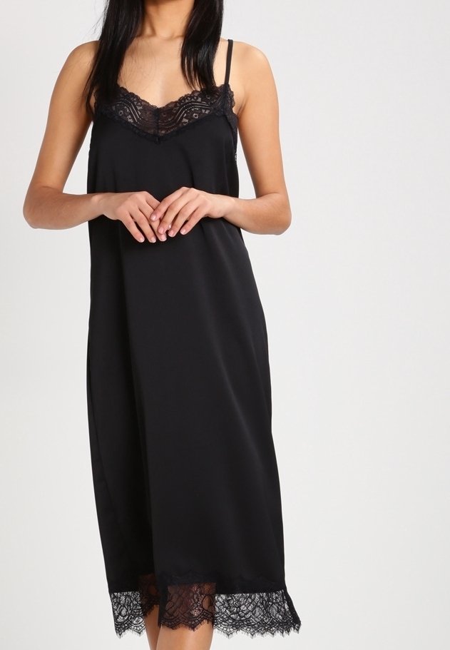 Musta satiini liukupuku säätöstrapeilla, jossa on pitsikoristelu kaula-aukossa ja helman reunassa. Sujuva tekstuuri koko matkalta.