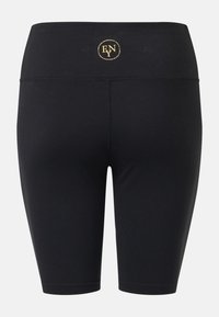 Shorts de cycliste taille haute noirs avec un petit logo doré circulaire sur la ceinture.