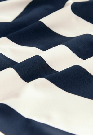 Jūras spēku un krējuma svītraina auduma ar gludu tekstūru, kas sastāv no maiņus platiem un šauriem svītrām, maigi salocīts un noliektas.