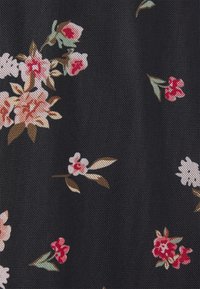Tissu noir avec un motif floral composé de fleurs roses, blanches et rouges, entourées de feuilles vertes, créant une texture délicate.