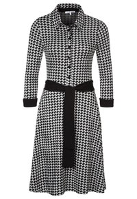 Robe à motif pied-de-poule noir et blanc avec col, boutonnage intégral sur le devant, manches longues et ceinture en tissu noir à la taille.