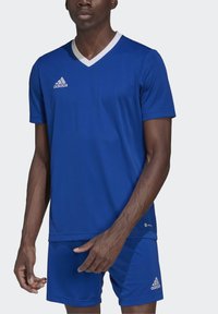 Blå atletisk fotballdrakt med hvit V-hals og korte ermer, laget av glatt stoff, kombinert med matchende shorts. Adidas-logoen er synlig.