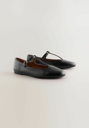 Schwarze Lederballerinas mit spitzem Zeh, ausgeschnittenem Design und Riemen am Knöchel mit goldfarbener Schnalle. Glatte Textur, niedriger Absatz.