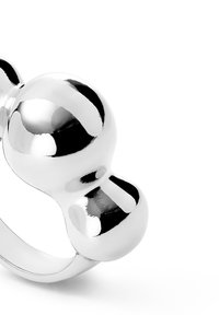 Bague en argent avec un design unique présentant deux formes sphériques reliées par un anneau lisse. Finition haute brillance avec une surface réfléchissante.
