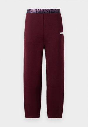 Joggers burdeos con una cinturilla elástica negra que presenta "ARMANI" en texto en contraste. Textura suave, diseño de pierna recta y sin bolsillos visibles.