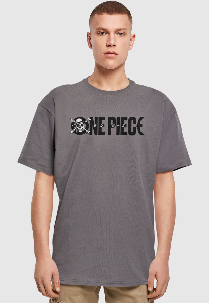 Grå bomulds t-shirt med et stort sort grafisk print af "ONE PIECE" og et kraniesymbol. Korte ærmer og et afslappet fit-design.