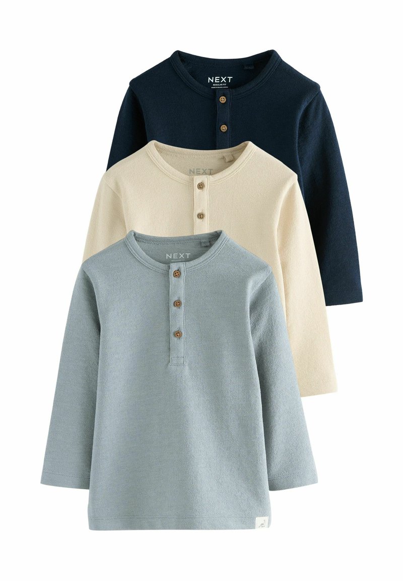 Ensemble de trois t-shirts à manches longues en bleu marine, crème et bleu clair. Chacun d'eux présente un col rond, une patte de boutonnage et une texture côtelée.