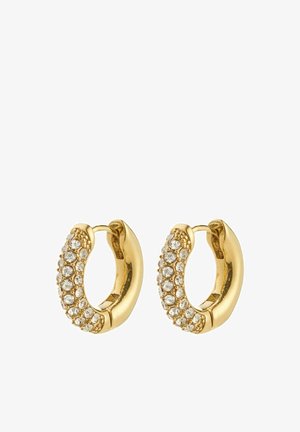 Zlaté náušnice kruhy s hladkým dizajnom a radom priehľadných kryštálov na jednej strane, poskytujúce textúrovaný a odrazový povrch.