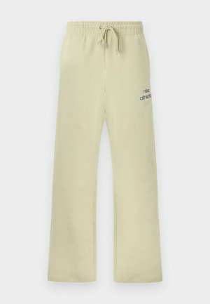 Μπεζ φόρμα Nike με ελαστική μέση, κορδόνι, χαλαρή εφαρμογή και το κείμενο "nike athletics" με το λογότυπο swoosh στη αριστερή μηρό.