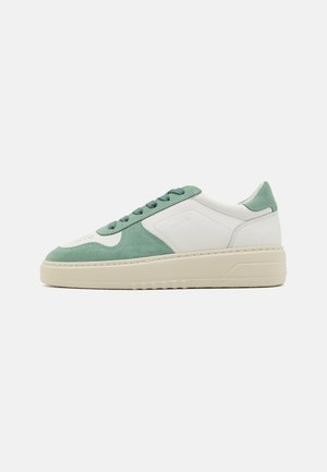Sneaker mit einem Obermaterial aus grünem Wildleder und weißem Leder, flachen grünen Schnürsenkeln, einer klobigen cremefarbenen Sohle und dezenten Nähdetails.