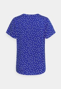 Blue short-sleeve t-shirt with white polka dots, round neckline, casual fit, soft fabric, and curved hem.
