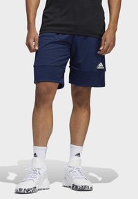 Marinefarbene Sportshorts aus feuchtigkeitsableitendem Material, mit einem elastischen Bund und glatter Textur. Adidas-Logo auf der Vorderseite.