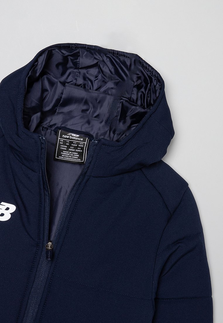 Veste à capuche bleu marine avec une doublure intérieure lisse et brillante. Comprend une fermeture éclair et un logo blanc sur le devant. Étiquette visible à l'intérieur.