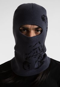 Pasamontañas de punto en azul marino oscuro, con aberturas para los ojos y un patrón gráfico en negro. Tela texturizada, ajuste ceñido, diseñado para el calor.