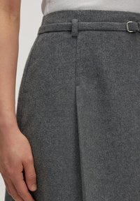 Grijze wolmix rok met een gladde textuur, voorzien van een riemlus en een strakke vormgeving, inclusief een zijplooidetail.
