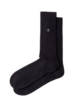 Pair of dark gray ribbed crew socks with a small white crossed golf clubs and ball logo near the top cuff.