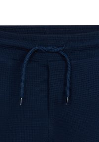 Marineblaue Jogginghosen aus strukturiertem Stoff mit einem elastischen Bund und Metallenden am Kordelzug.