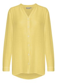 Blusa gialla chiara a maniche lunghe con bottoni, scollo a V e tessuto leggermente strutturato, con maniche a polsino e orlo leggermente curvo.