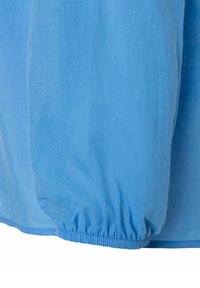 Hellblaues Hemd mit einer glatten, weichen Textur, gesammelten elastischen Manschetten und einem abgerundeten Saum für eine lässige Passform.