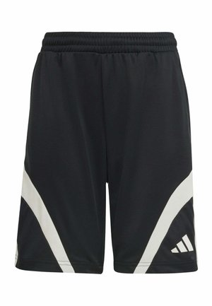 Dos niños con ropa deportiva Adidas blanca y negra a juego, de pie y sonriendo frente a un fondo sencillo.