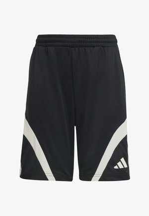 Dos niños con ropa deportiva Adidas blanca y negra a juego, de pie y sonriendo frente a un fondo sencillo.
