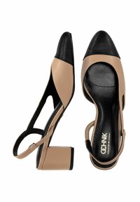 Beżowe i czarne sandały na wysokim obcasie z otwartymi bokami i blokowym obcasem. Posiadają szpiczasty czubek i krzyżujące się paski.