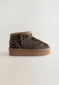 Ankelstøvle med leopardprint lavet af blødt stof, med en brun gummisål og syet detaljering langs overdelen.