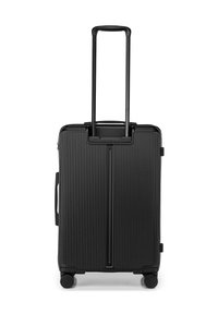 Black hard-shell spinner suitcase with vertical ribbed texture, retractable handle, and four wheels for mobility. Side handle included.