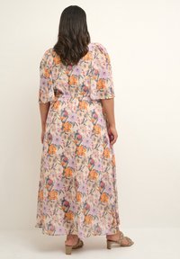 Robe maxi fleurie en violet clair avec des fleurs orange, roses et bleues. Manches courtes, taille ajustée et jupe fluide. Tissu lisse et léger.