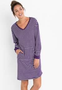 Robe a righe viola e bianche con scollatura a V, maniche lunghe e una grande tasca frontale. Il tessuto sembra morbido e informale. Orlo arrotondato.