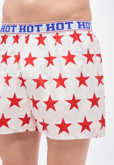 Λευκά μποξεράκια με μοτίβο κόκκινου αστεριού και μπλε μέση με κείμενο «HOT HOT HOT». Το ύφασμα φαίνεται λείο και ελαφρύ.