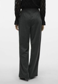 Pantaloni a gamba larga grigio scuro in un tessuto testurizzato con una vita liscia, caratterizzati da sottili strisce verticali e una finitura sartoriale.