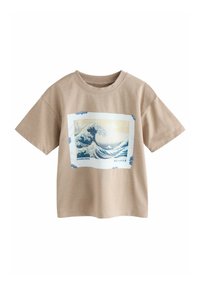 Camiseta de algodón beige de manga corta, con un estampado gráfico de ola en azul, rodeado por un marco rectangular blanco con acentos azules.