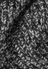Mustritud kudum black ja white tooni, millel on herringbone muster ja pehme, karvane välimus. Tihe ja kergelt kootud viimistlus.