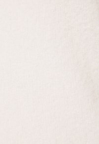 Weißer Stoff mit einer weichen, strukturierten Oberfläche. Das Material wirkt leicht und leicht flauschig und weist ein gleichmäßiges Muster auf.