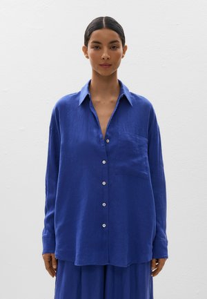 Blauw linnen overhemd met knopen, kraag, lange mouwen en een borstzak. Heeft een ontspannen pasvorm en subtiele textuur.
